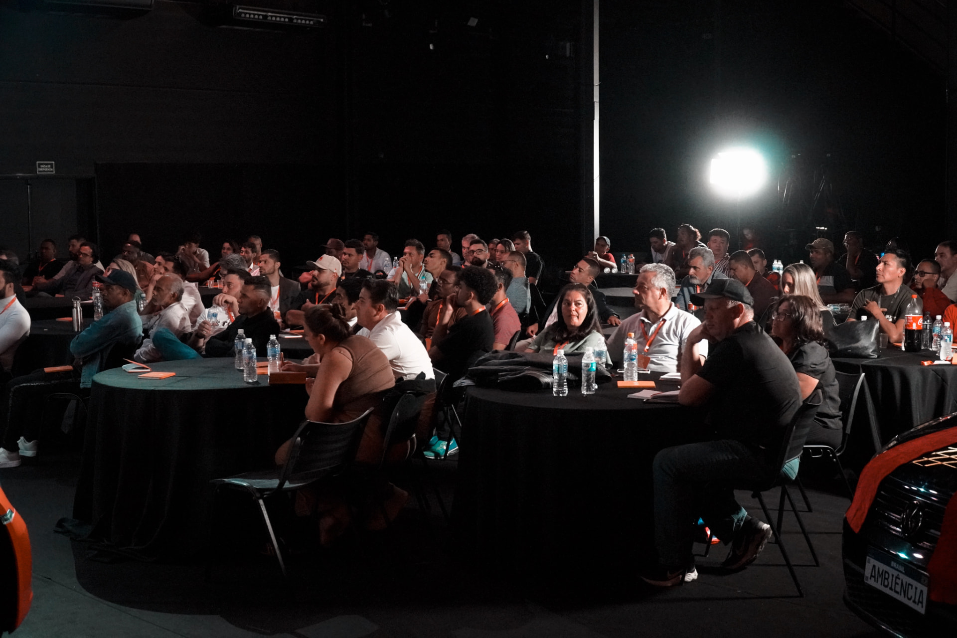 Público sentado em mesas acompanha a apresentação do ADL Festival